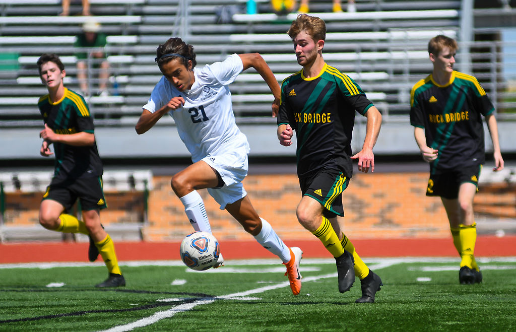 Evan Yalavarthi of the SLUH Jr. Bills sprints past Rock Bridge midfielder